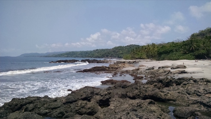 Rocky shore and sand at low tide on the coast near Montezuma